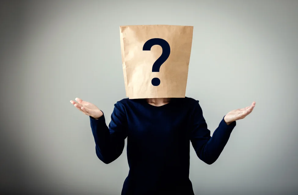 A person with a paper bag marked with a question mark over their head